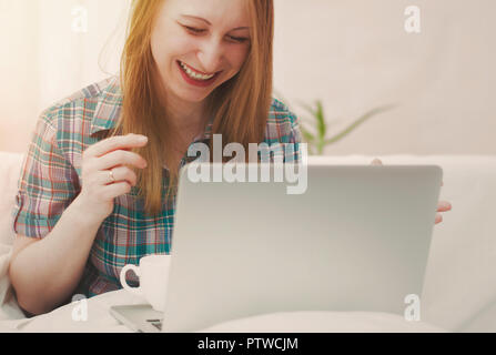 Mädchen lacht Arbeiten für den Laptop. Stockfoto
