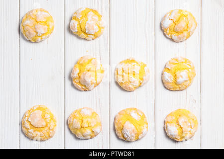 Hausgemachte Zitrone crinkle Plätzchen mit Puderzucker Puderzucker. Risse citrus Kekse auf weißem Holz- Hintergrund. Von oben nach unten Stockfoto