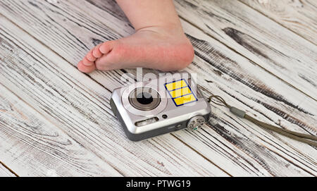 Baby Fuß und Digitalkamera, weiß Holz- Hintergrund, Nahaufnahme Stockfoto