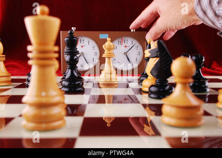 Holz- Schach und Hand, eine schachuhr beginnt Stockfoto