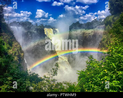 Doppelter Regenbogen über Victoria Falls in Zambia, Afrika an einem sonnigen Tag Stockfoto