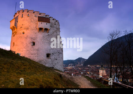 Der Weiße Turm Bastion aus Brasov, die in den mittelalterlichen Zeiten gebaut, um die Stadt zu schützen. Nachtansicht der towe und der Stadt. Stockfoto