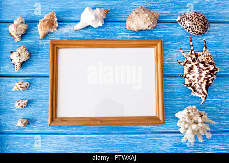 Muscheln und Rahmen auf einem blauen Hintergrund Holz, leere Rahmen für eine Inschrift Stockfoto