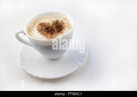 Eine Tasse Kaffee auf einem weißen Hintergrund ein Herz aus Zimt gemacht Stockfoto