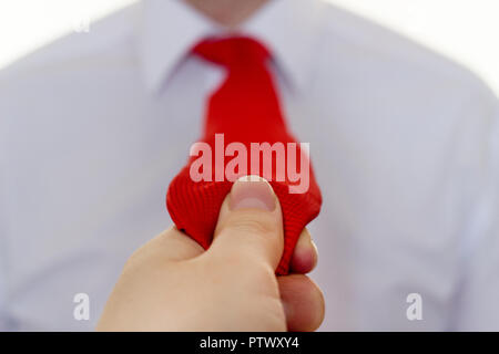 Mädchen, dass eine rote Krawatte ein Mann in einem weißen Hemd, close-up Stockfoto