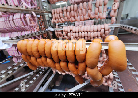 Würstchen in einer Räucherkammer close-up gegen eine Fleisch-Verpackungsanlage Stockfoto