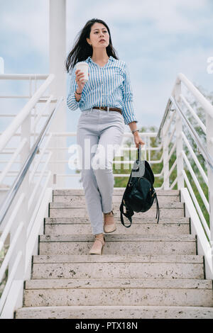 Ein Foto von einem weiblichen Reisenden zu Fuß die Treppe hinunter und ihrem Rucksack tragen Stockfoto