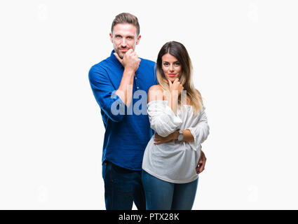 Junge Paare, die in Liebe über isolierte Hintergrund in die Kamera schaut zuversichtlich mit Smile mit verschränkten Armen und Hand am Kinn angehoben. Denken positiv. Stockfoto