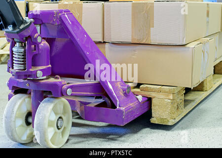 Lila Handhubwagen mit Kartons. Stockfoto