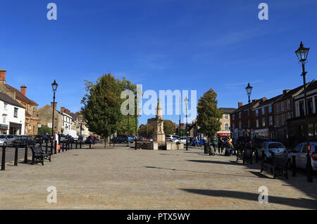 An einem schönen Herbstmorgen die Sonne auf der Market Street in Brackley in Northamptonshire, als Menschen unterwegs sind. Stockfoto