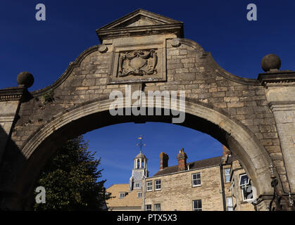 An einem schönen Herbst Morgens scheint die Sonne auf den Stein Arbeit Der Hof arch an der Seite des Rathauses in Brackley in Northamptonshire. Stockfoto