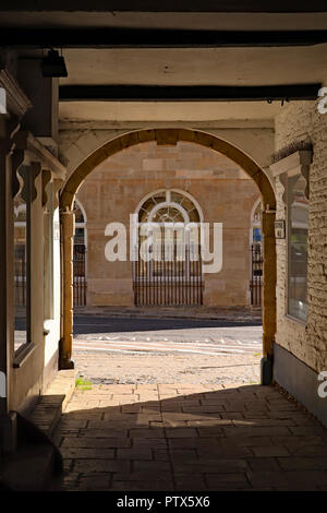 An einem schönen Herbst Morgens scheint die Sonne auf den Stein Arbeit Der Hof arch an der Seite des Rathauses in Brackley in Northamptonshire. Stockfoto