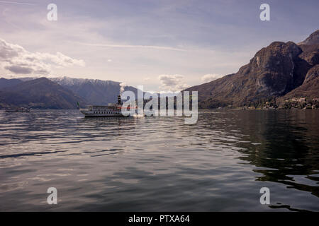 Menaggio, Italy-April 2, 2018: Concordia Fähre auf dem Comer see Leute transportieren mit Berg im Hintergrund Stockfoto