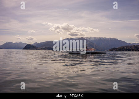 Menaggio, Italy-April 2, 2018: Concordia Fähre auf dem Comer see Leute transportieren mit Berg im Hintergrund Stockfoto