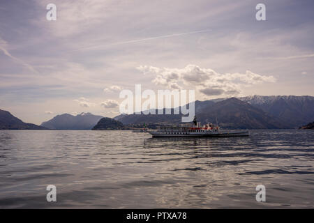 Menaggio, Italy-April 2, 2018: Concordia Fähre auf dem Comer see Leute transportieren mit Berg im Hintergrund Stockfoto