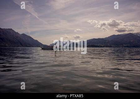 Menaggio, Italy-April 2, 2018: Concordia Fähre auf dem Comer see Leute transportieren mit Berg im Hintergrund Stockfoto