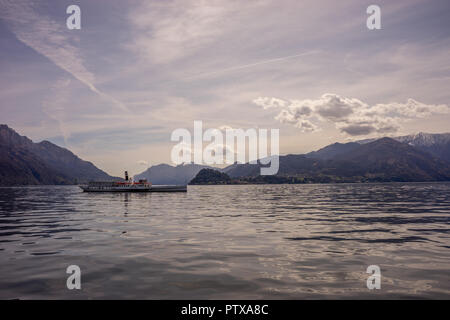 Menaggio, Italy-April 2, 2018: Concordia Fähre auf dem Comer see Leute transportieren mit Berg im Hintergrund Stockfoto