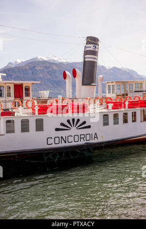 Menaggio, Italy-April 2, 2018: Concordia Fähre auf dem Comer see Leute transportieren mit Berg im Hintergrund Stockfoto