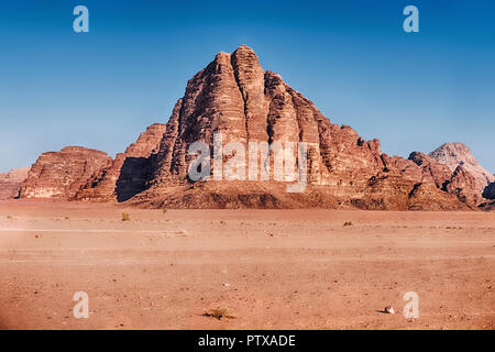 Im Wadi Rum Wüste im südlichen Jordanien, die Landschaft wird durch die Klippen und Strebepfeiler der Berg der sieben Säulen dominiert. Stockfoto