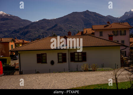 Menaggio, Italy-April 2, 2018: Blick auf ein Gebäude aus Stein mit einem Berg im Hintergrund in Menaggio, Lombardei Stockfoto