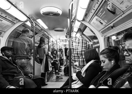 Schwarz & Weiß, Natur schoss der Passagiere bei London Rohr, Innen besetzt Waggon; miserable Pendler Stehen und Sitzen, keine Interaktion. Stockfoto