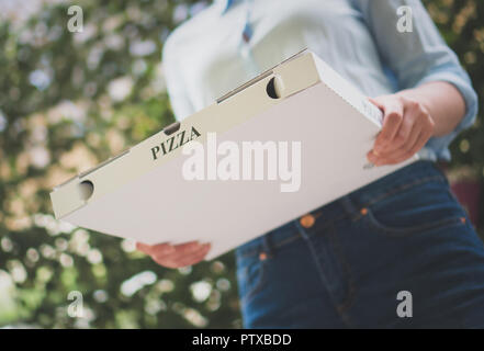 Pizza Delivery Frau mit pizza box. Stockfoto