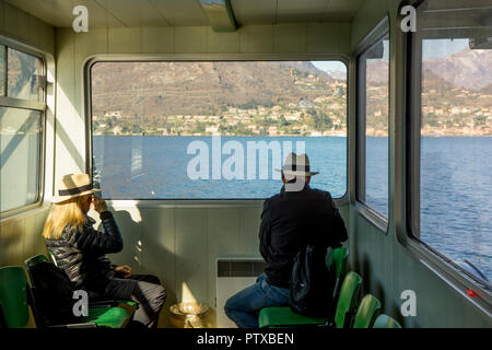 Menaggio, Italy-April 2, 2018: die Menschen sitzen auf einem Boot im Wasser in der Nähe eines Fensters, Lombardei Stockfoto