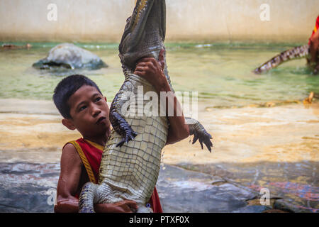 Samut Prakarn, Thailand - 25. März 2017: Junge und sein Team in der gefährlichen Krokodil zeigt. Riskante Krokodil zeigt in Crocodile Farm, einer der am meisten Impr Stockfoto