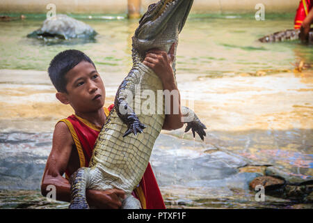 Samut Prakarn, Thailand - 25. März 2017: Junge und sein Team in der gefährlichen Krokodil zeigt. Riskante Krokodil zeigt in Crocodile Farm, einer der am meisten Impr Stockfoto