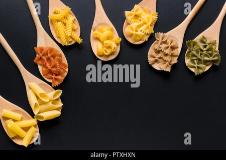 Verschiedene Arten von italienischen Pasta in Löffel aus Holz. Stockfoto