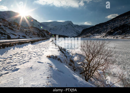 Gefrorenen See und schneebedeckte Berge in Snowdonia, North Wales Stockfoto