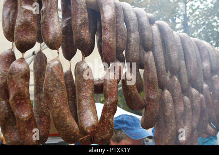 Würstchen. Würstchen hängen im Freien zum Verkauf auf einem Straßenmarkt. Hausgemachte Fleisch salami Wurst am Markt hängen in Zeile unter Sonnenlicht gut zu bilden Stockfoto