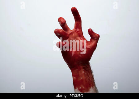 Blutige Hand gegen einen hellen Hintergrund. Halloween Horror Konzept Stockfoto