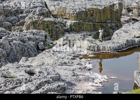 STUDEN KLADENETZ, Bulgarien - Mai 2, 2015: erwachsene Frau in touristische Kleidung nimmt Schnappschüsse mit Handy bei Devil Canyon natürliches Phänomen auch bekannt Stockfoto