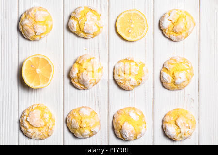 Hausgemachte Zitrone crinkle Plätzchen mit Puderzucker Puderzucker. Risse citrus Kekse auf weißem Holz- Hintergrund Stockfoto