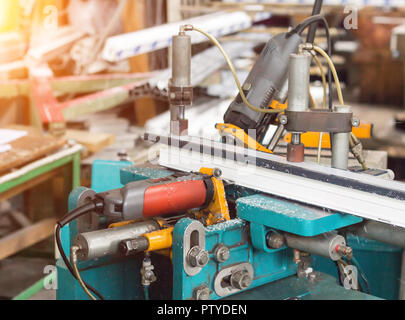 Herstellung von PVC-Fenstern, eine Maschine zum Bohren von Löchern im Rahmen aus PVC, Bohren Werkzeug Stockfoto