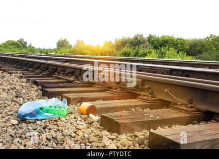 Ein Paket mit Müll auf der Schiene aus dem Fenster des Zuges geworfen, die von den Passagieren, Umweltverschmutzung, Ablagerungen und die Eisenbahn, Wurf Stockfoto