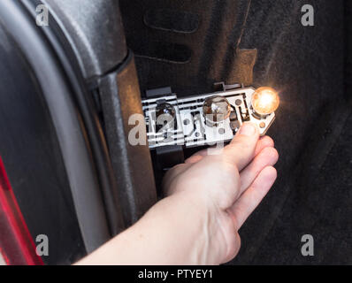 Männliche Hand, Austausch einer Glühlampe in die hinteren Scheinwerfer eines Autos, close-up Stockfoto