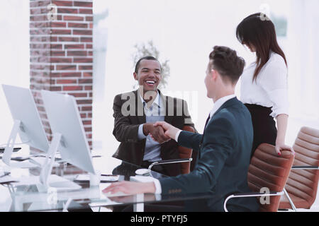 Handshake Geschäft Leute hinter einem Schreibtisch im Büro Stockfoto