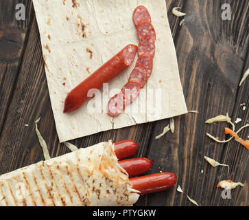 Geräucherte Wurst in pita Brot auf einem Holztisch Stockfoto