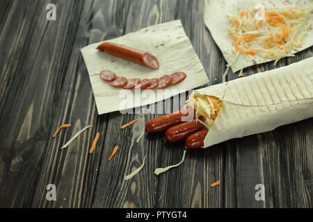 Geräucherte Wurst in Fladenbrot gewickelt. Foto mit Kopie Raum Stockfoto