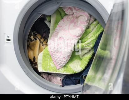 Bunte schmutzige Wäsche im Wäschekorb auf weißem Hintergrund Stockfoto