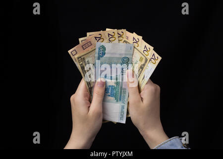 Mädchen in Händen halten, Geld, Euro, Rubel und Euro, schwarzer Hintergrund, close-up Stockfoto