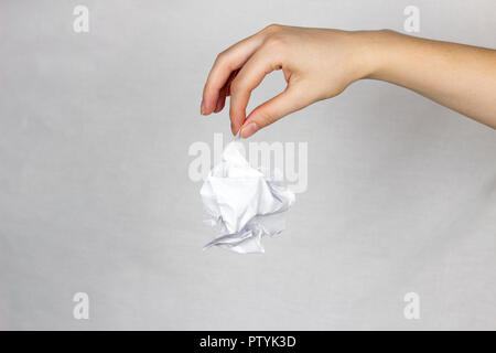 Eine weibliche Hand hält ein zerknittertes Blatt Stockfoto