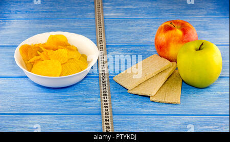 Chips äpfel Brot zentimeter Band auf einem blauen Hintergrund aus Holz Stockfoto