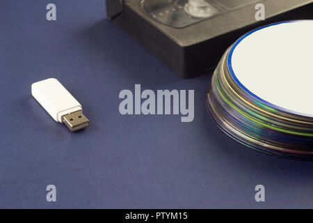 White flash drive auf blauem Hintergrund video Kassette und Compact Discs Stockfoto