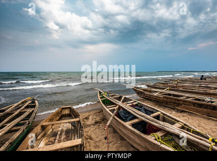 Burundi Bujumbura Lake Tanganyika, windiger bewölkter Himmel und Sand Strand am See in Ostafrika, Burundi Sonnenuntergang mit Boote aus Holz. Sturm Wetter Stockfoto