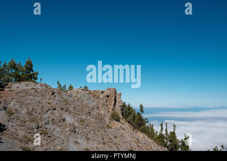 Klippe über den Wolken mit klarem, blauem Himmel Hintergrund Stockfoto