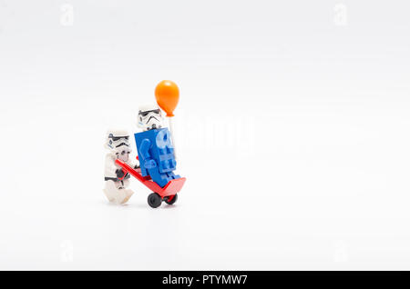 Lego Sturmtruppen drücken Trolley mit einer von Ihnen auf Wagen trägt blaue Ziegel mit einem Ballon. Stockfoto