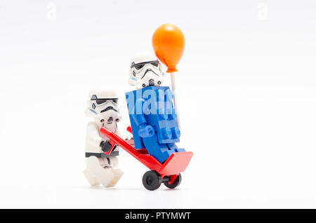 Lego Sturmtruppen drücken Trolley mit einer von Ihnen auf Wagen trägt blaue Ziegel mit einem Ballon. Stockfoto